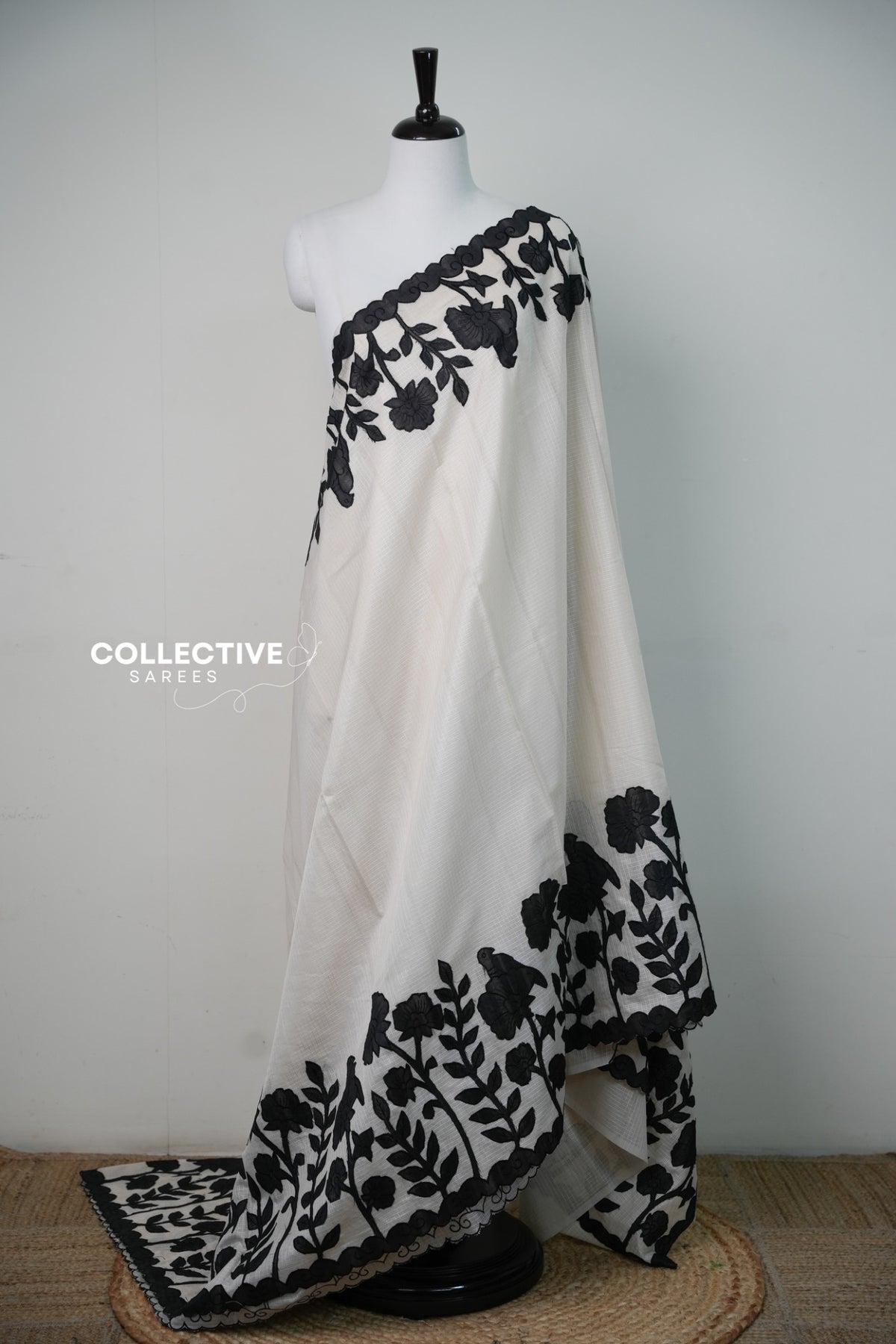 Kota off-white saree with black floral appliqué work — full drape