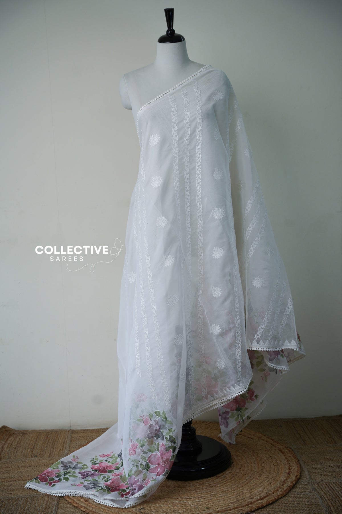 White organza saree with embroidered vine stripes and watercolour floral pallu, full drape on mannequin