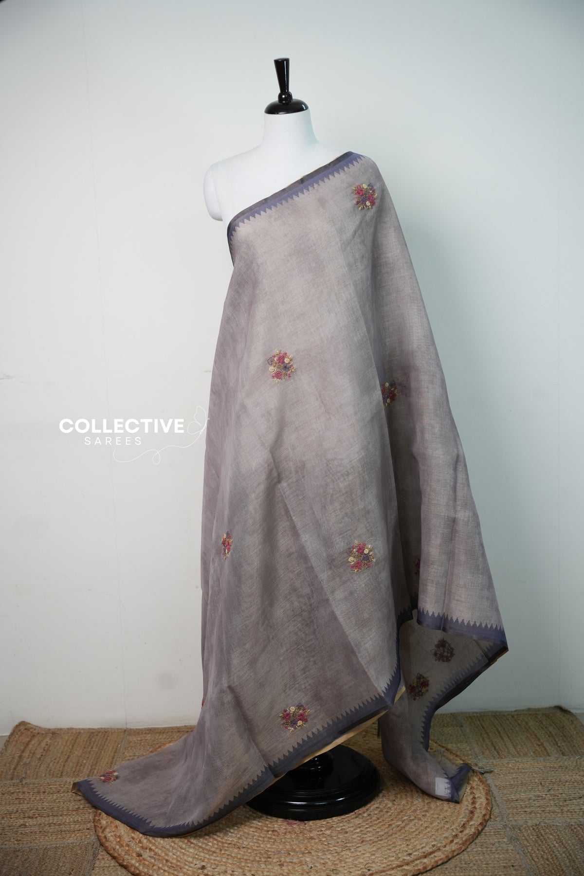 Light ash semi tissue saree with hand-embroidered florals and slate temple border, full drape