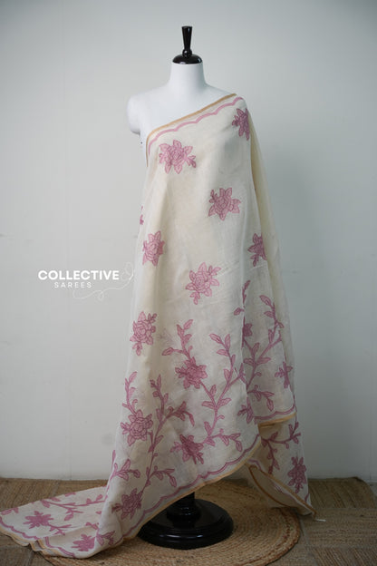 Beige soft tissue saree with pink floral appliqué work and gold-toned edging