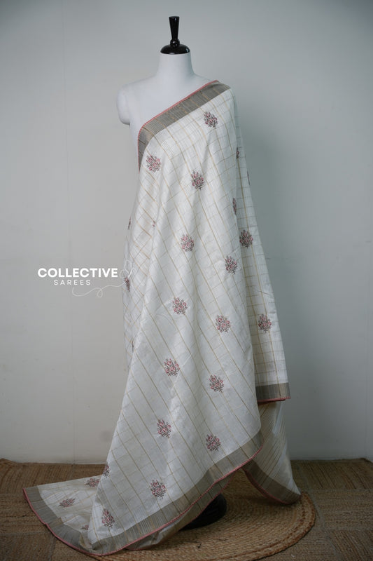 Cream soft tissue saree with gold-toned checks and pink floral motifs — view 1