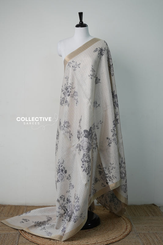 Cream semi tissue saree with warm grey rose print and gold zari border, full drape