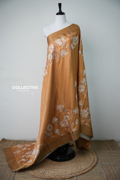 Mustard semi tussar saree with ivory embroidered florals and gold border, full drape